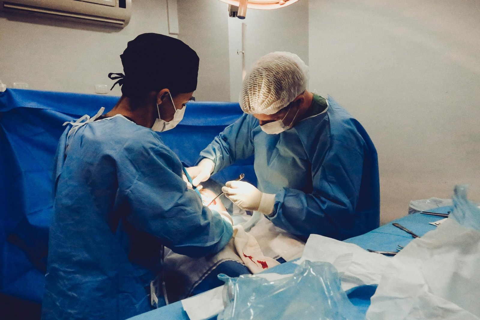 Surgeons focusing on a procedure in an equipped operating room, showcasing teamwork and precision.